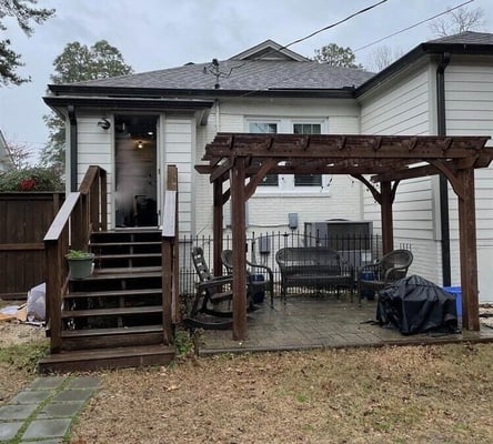 Exterior of home with wood steps and wood pergola
