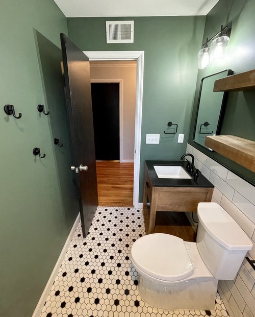 Remodeled bathroom with tile floor and green walls