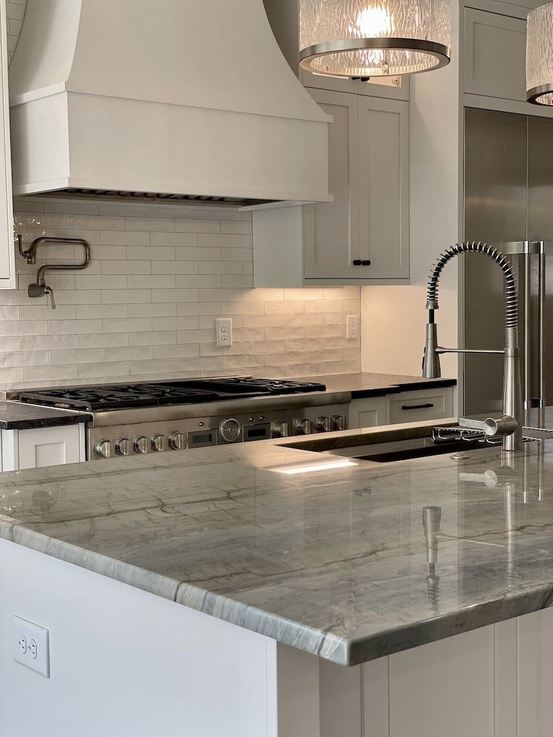 Remodeled kitchen with gray granite counter tops and white cabinets