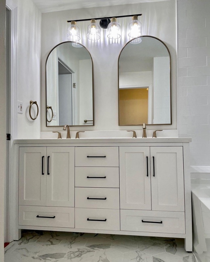 Bathroom countertop with double sinks and arched mirrors