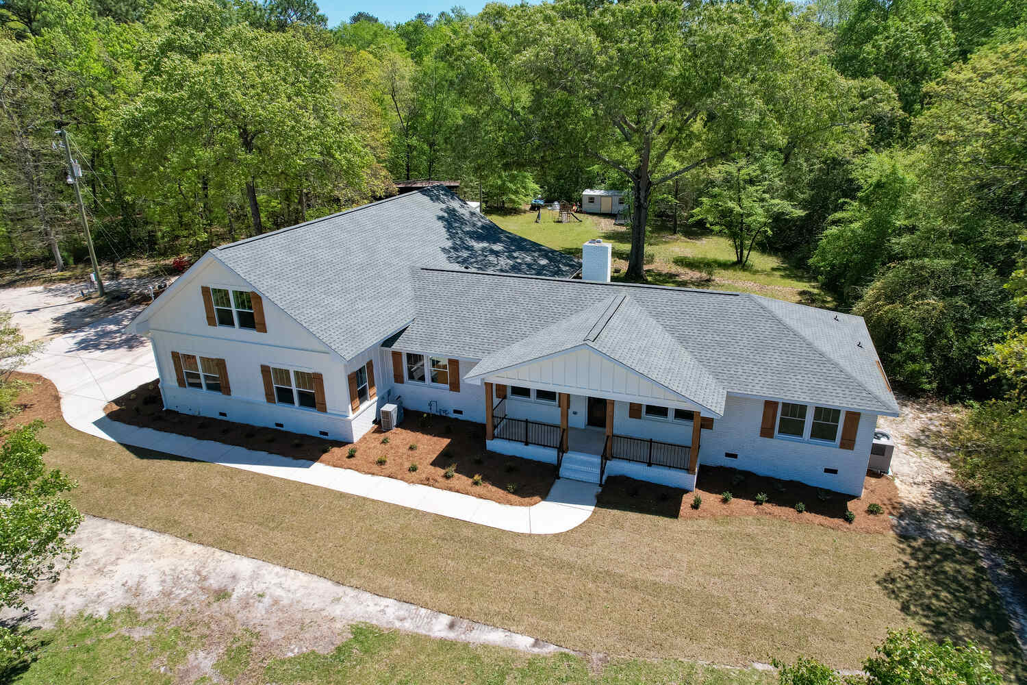 Exterior of home with white siding and wood window shutters